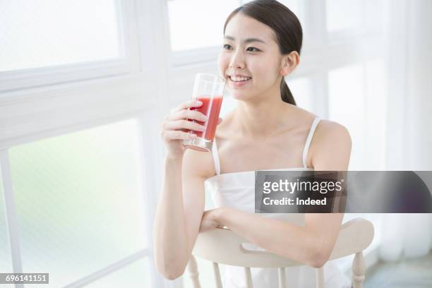 young woman drinking vegetable juice - キャミソール ストックフォトと画像