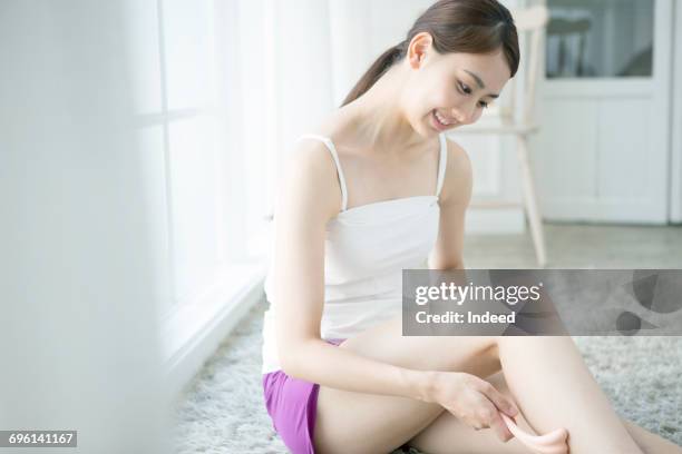 young woman massaging her leg  - cami - fotografias e filmes do acervo