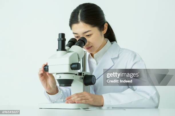 woman scientist using microscope - microscope fotografías e imágenes de stock