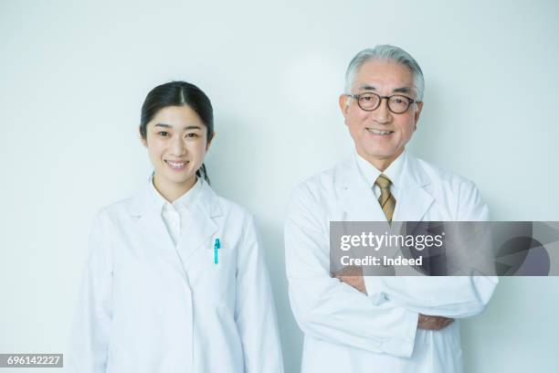 portrait of make and female scientists - senior woman smiling at camera portrait stock-fotos und bilder