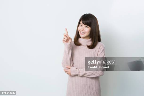 young woman pointing index finger - index finger fotografías e imágenes de stock