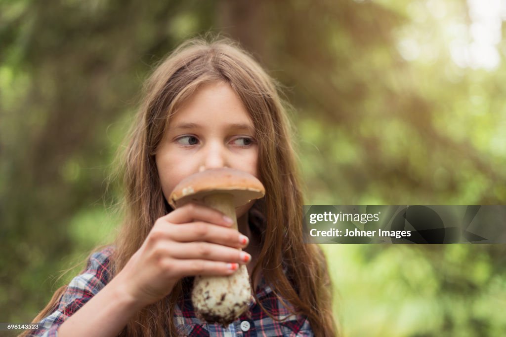 Girl smelling mushroom