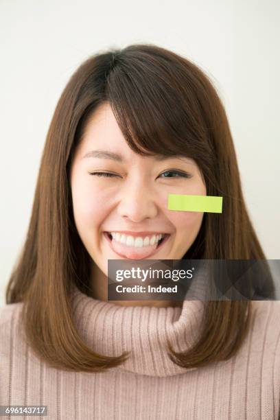 young woman with sticky note smiling - cheek tongue stock pictures, royalty-free photos & images