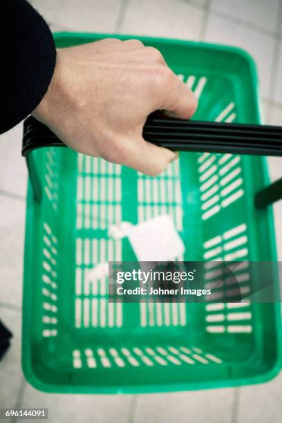 hand holding shopping basket - einkaufskorb stock-fotos und bilder
