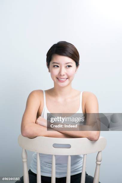 young woman sitting on chair, portrait - at a glance ストックフォトと画像