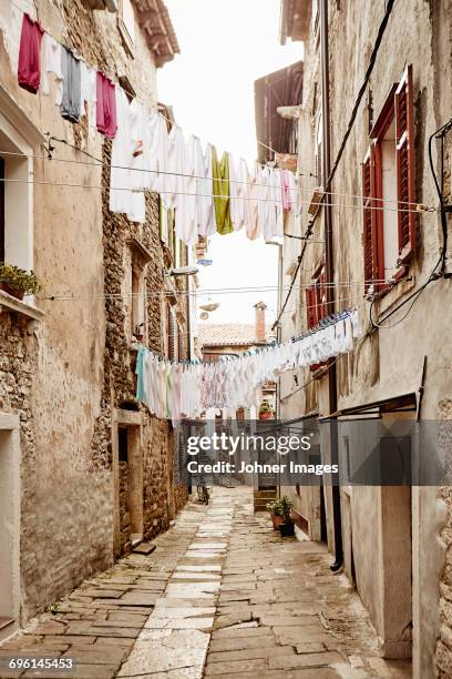 laundry hanging above narrow street - gamla stan stock pictures, royalty-free photos & images
