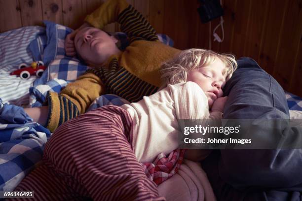 mother and daughter sleeping on bed - mother sleeping child stock-fotos und bilder