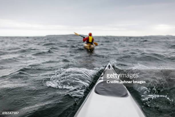 person kayaking on sea - gray boot stockfoto's en -beelden