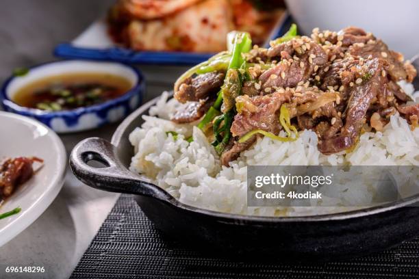 köstliche bulgogi mariniert in sojasauce, knoblauch und ingwer, gedünsteter reis - rice bowl stock-fotos und bilder