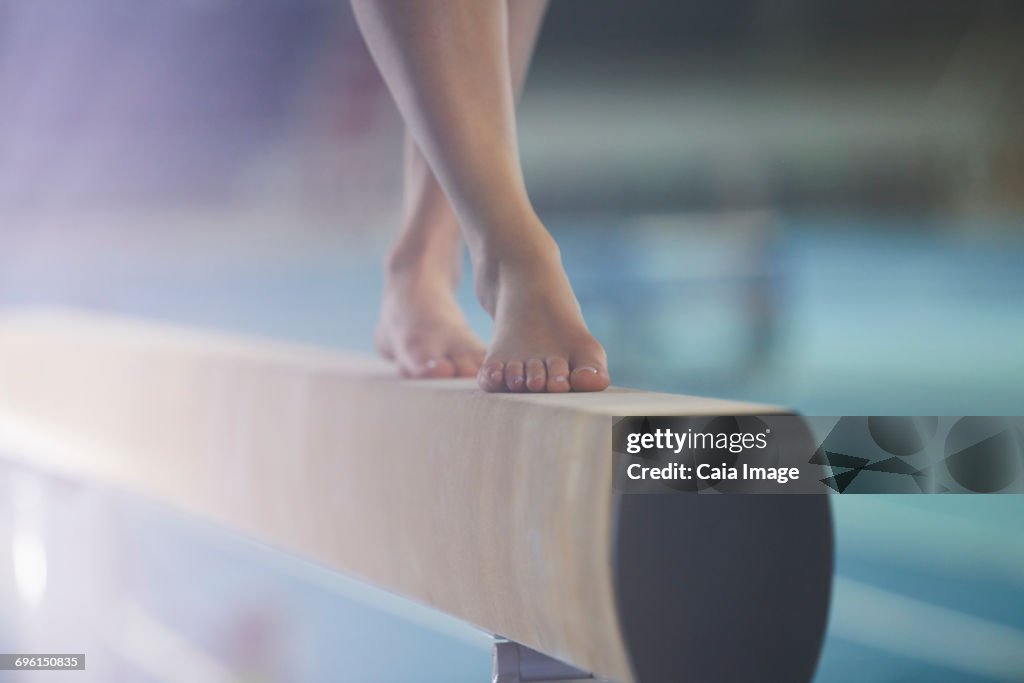 Bare feet of female gymnast performing on balance beam