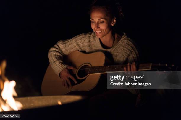 woman playing guitar - brand on guitar stock-fotos und bilder