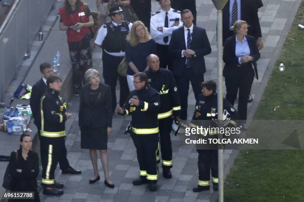 British Prime Minister Theresa May visits the remains of Grenfell Tower, a residential tower block in west London which was gutted by fire on June...