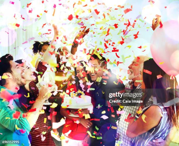 family throwing confetti celebrating birthday party with cake - throwing cake stock pictures, royalty-free photos & images