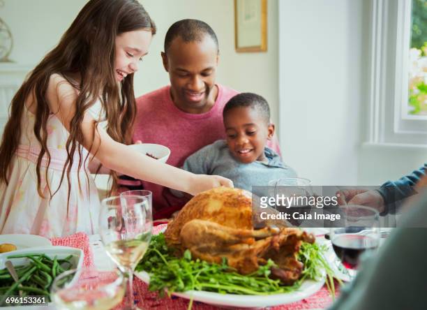 multi-ethnic family enjoying christmas turkey dinner at table - leanintogether stock pictures, royalty-free photos & images