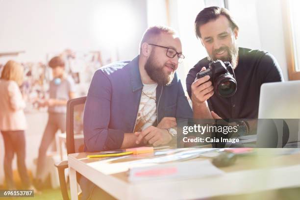 photographer design professionals with slr camera in office - future proof stock-fotos und bilder