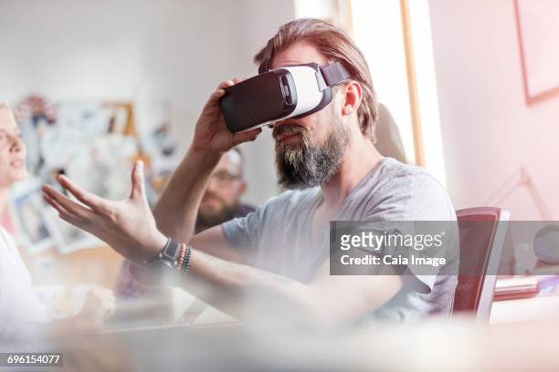 male design professional using virtual reality simulator glasses in office - virtualitytrend stock pictures, royalty-free photos & images