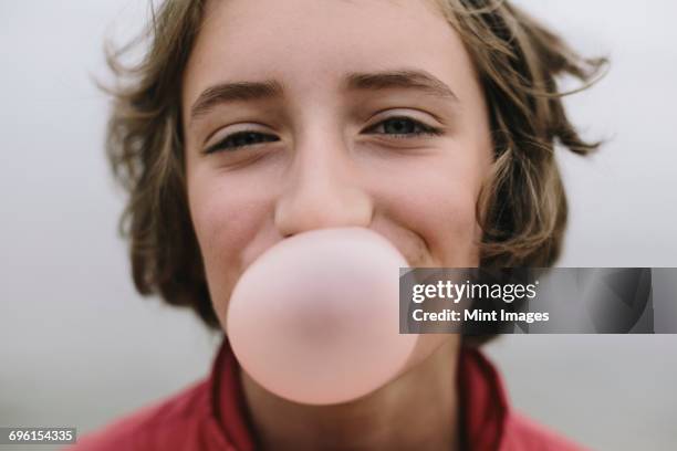 eleven year old girl blowing bubble gum bubble - bubble gum stockfoto's en -beelden