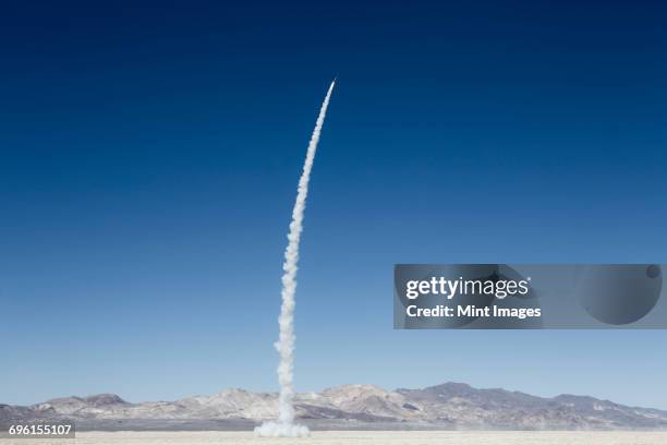 rocket shooting into vast, desert sky, black rock desert, nevada - rocket stock pictures, royalty-free photos & images