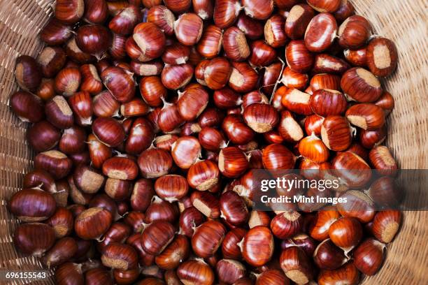 a basket of roasted sweet edible chestnuts. - chataignes photos et images de collection