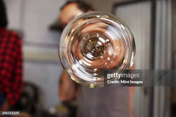 a glass at the end of a tube, a glassblower at work. - glass blowing stockfoto's en -beelden