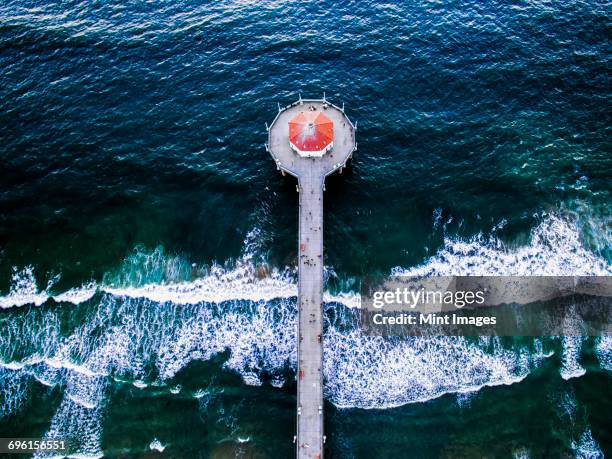 aerial view of the manhattan beach pier and waves breaking on the shore. - manhattan beach photos et images de collection