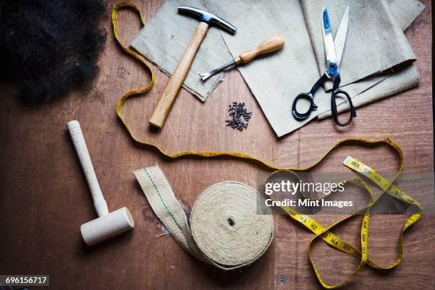 upholstery workshop. overhead view of hand tools, hammer, tape, tape measure and scissors. - upholstery worker stock pictures, royalty-free photos & images