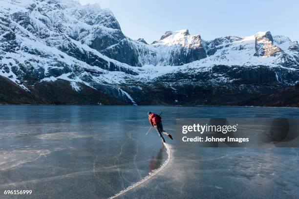 man ice-skating on frozen lake - アイススケート ストックフォトと画像