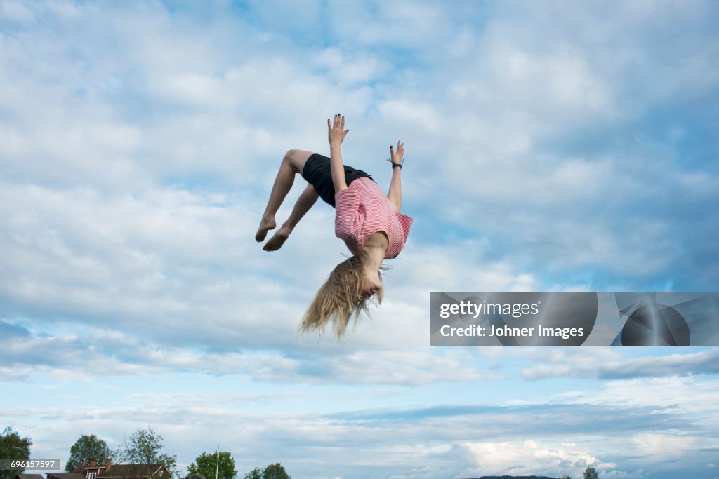 Girl doing somersault mid-air