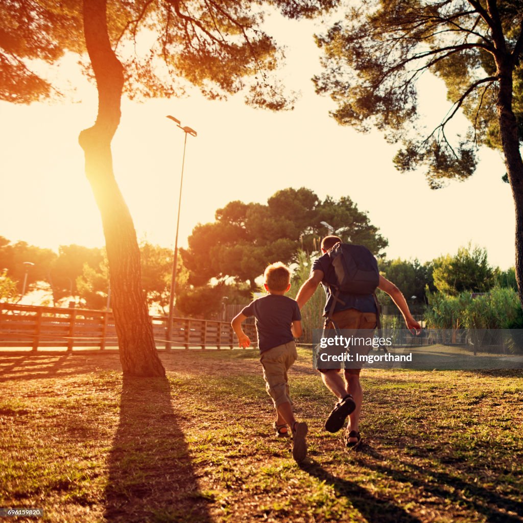 Father and son running in the city park