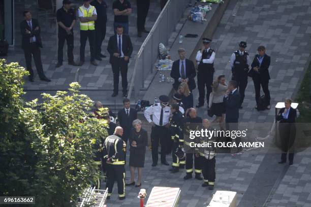 British Prime Minister Theresa May visits the remains of Grenfell Tower, a residential tower block in west London which was gutted by fire on June...