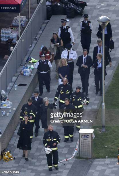 British Prime Minister Theresa May visits the remains of Grenfell Tower, a residential tower block in west London which was gutted by fire on June...