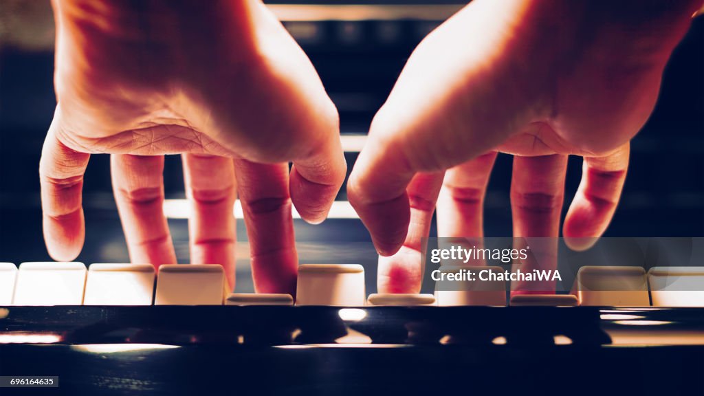Close-up of a woman's hands playing the piano