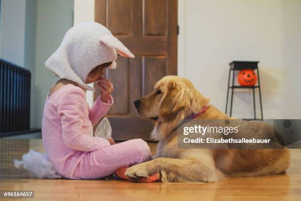 girl in bunny costume sharing halloween candy with golden retriever dog - dog eating a girl out stock pictures, royalty-free photos & images