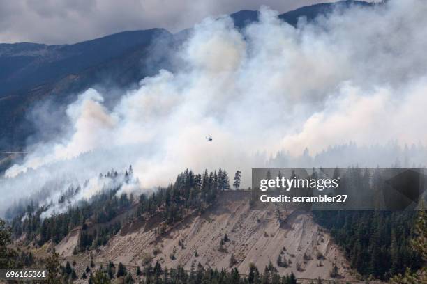 helicopter flying over forest fire in lytton, british columbia, canada - forest fire stock pictures, royalty-free photos & images