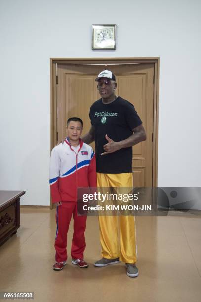 Former NBA star Dennis Rodman of the US poses with Olympic gymnast Ri Se Gwang of North Korea, at the Pyongyang Indoor Stadium on June 15, 2017...