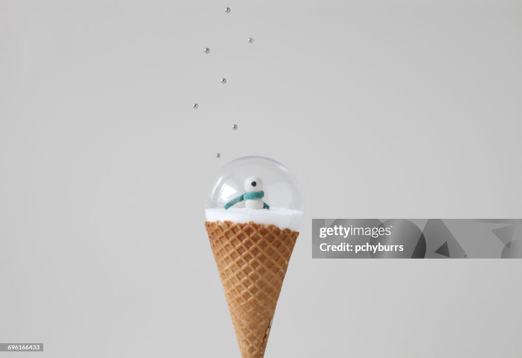 Snow globe on ice cream cone with sprinkles