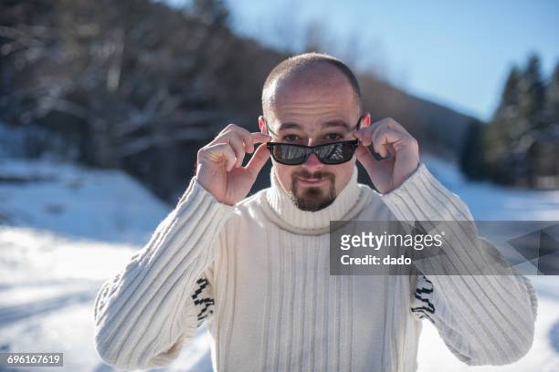portrait of a man looking over the top of his sunglasses - ergens overheen kijken stockfoto's en -beelden