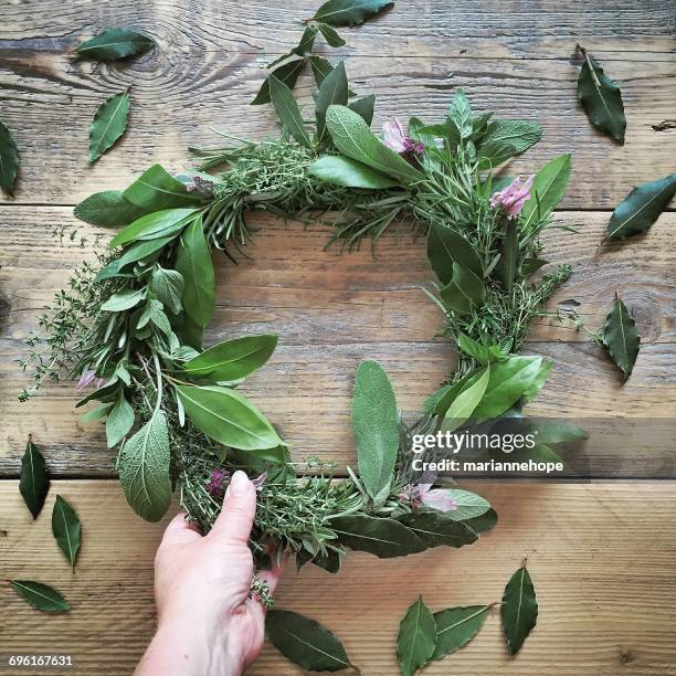 woman's hand holding wreath of herbs - wreath making stock pictures, royalty-free photos & images