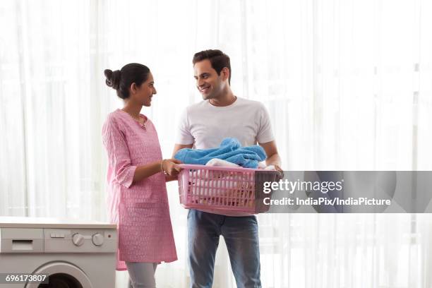 couple holding laundry basket together - laundry basket stock pictures, royalty-free photos & images