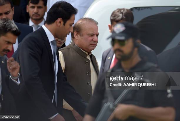 Pakistan's Prime Minister Nawaz Sharif is escorted by security personnel as he leaves after appearing before an anti-corruption commission at the...