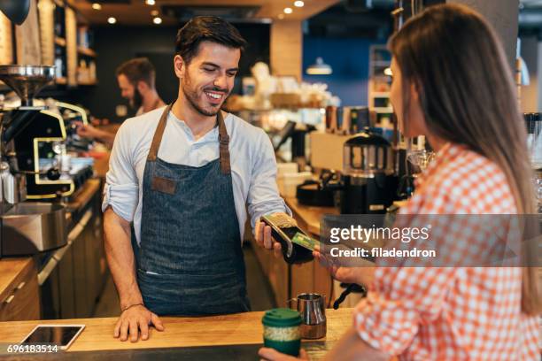 customer making a contactless payment - georgian man stock pictures, royalty-free photos & images