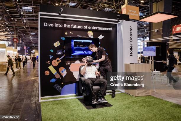 An attendee wears a virtual reality headset at the Orange SA tech lab exhibition stand during the Viva Technology conference in Paris, France, on...