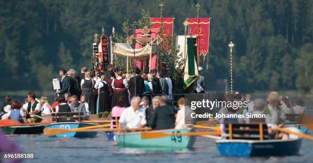 Participants dressed in traditional Bavarian folk outfits cross in boats the Staffelsee Lake in the annual Corpus Christi procession on June 15, 2017...