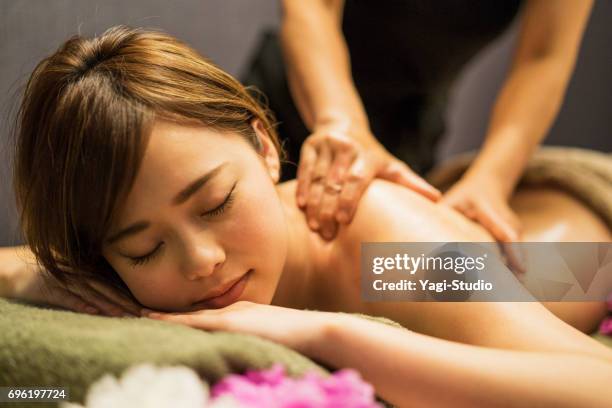 young woman receiving oil massage - spa treatment stock pictures, royalty-free photos & images