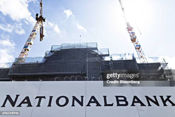Construction cranes stand behind hoardings at the Swiss National Bank as it undergoes renovation in Bern, Switzerland, on Thursday, June 15, 2017....
