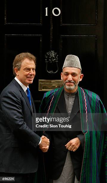 Interim Afghan leader Hamid Karzai shakes hands with British Prime Minister Tony Blair January 31 2002 at the door of Number 10 Downing Street in...