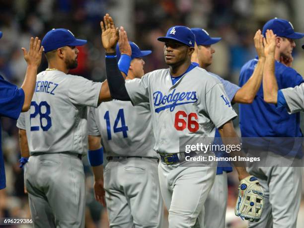 Rightfielder Yasiel Puig of the Los Angeles Dodgers high fives leftfielder Franklin Gutierrez after winning a game on June 13, 2017 against the...