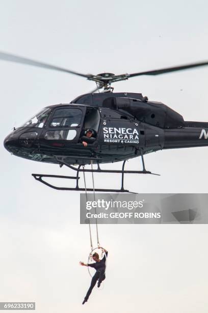 Aerialist Erendira Wallenda hangs beneath a helicopter during a stunt over the Horseshoe Falls at Niagara Falls, New York, June 15, 2017. / AFP PHOTO...