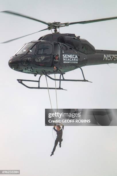 Aerialist Erendira Wallenda hangs beneath a helicopter during a stunt over the Horseshoe Falls at Niagara Falls, New York, June 15, 2017. / AFP PHOTO...