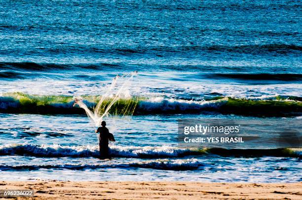 lifestyle - fisherman playing fishing net - fisherman isolated stock pictures, royalty-free photos & images